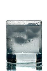 Water. A glass with water and an ice on a white background