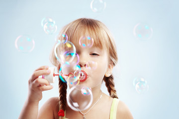 Little girl blowing bubbles