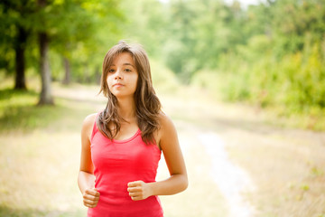 Fototapeta premium Woman jogging through a forest