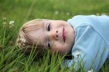 Kleiner Junge im Gras liegend