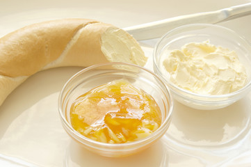 croissant with yellow plum jam, butter and knife