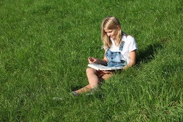 Lesendes Mädchen auf Wiese