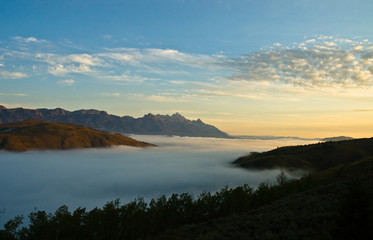 Fototapeta na wymiar Mountain range and a valley of fog at daybreak