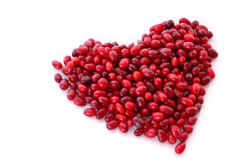 cranberries in heart shape over white background