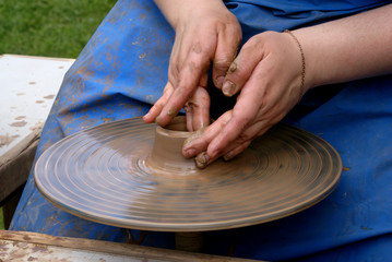 Potter shaping clay on a potter's wheel