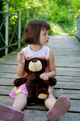 5 years old girl on the bridge with teddy bear