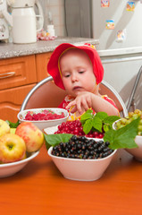 The little girl eats a berry