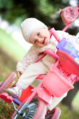 Child sits on a tricycle.