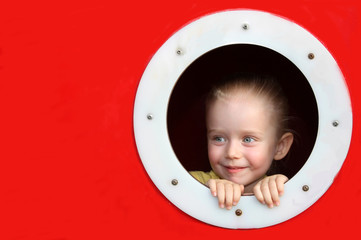 Little girl looking through circle window