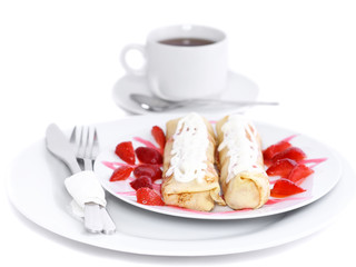 Pankcake with rolled fruit inside and strawberry around.