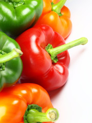 Colored paprikas on white background