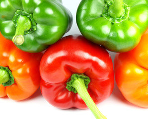 Colored paprikas on white background