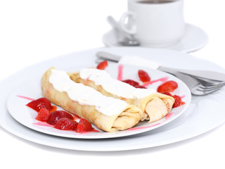 Pankcake with rolled fruit inside and strawberry around.