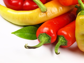 Colored paprikas on white background
