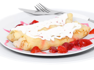Pankcake with rolled fruit inside and strawberry around.