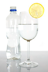 Bottle and glass of water with lemon slice