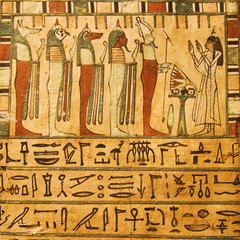 Ancient Egyptian gods and hieroglyphics painted on stone