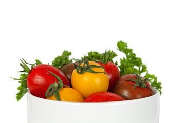 small tomatoes in bowl, isolated on white background