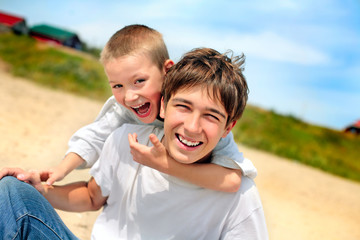 happy teenager and kid on the beach