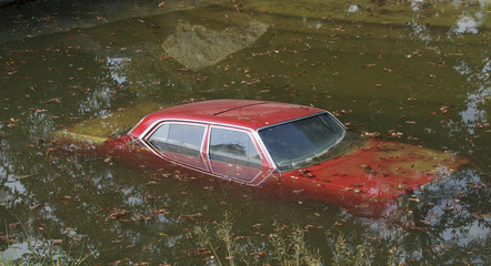 Rotes Auto versinkt im See