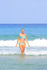 tanned blond woman in bikini in the sea