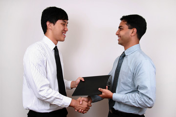 Indian and Chinese businessman exchanging a file.