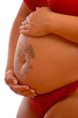 Babybauch mit Tattoo und Piercing