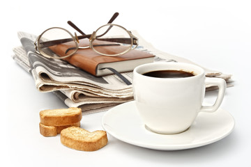 Cup of hot coffee and newspaper with glasses on white background