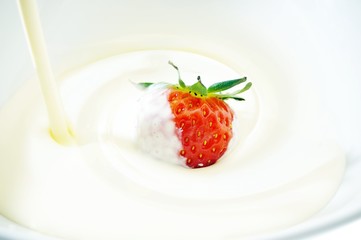 cream being pored over strawberry