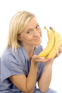smiling happy nurse doctor with healthy fresh bunch ripe bananas