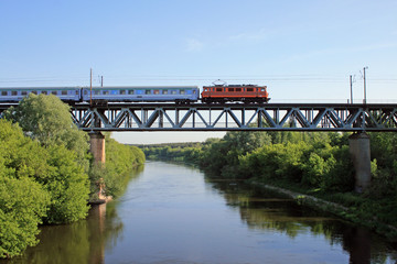 Naklejka premium Pociąg Intercity przechodzący przez stalowy most nad rzeką