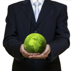 Businessman holding green planet