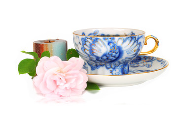 Rose, candle and blue cup of tee.