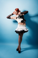 Portrait of attractive girl in paper dress over blue