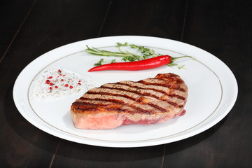 Juicy beef steak with red chili pepper and rosemary