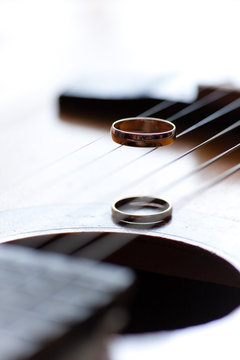Two wedding rings are on guitar stripes