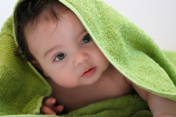 Bébé curieux dans sa serviette verte