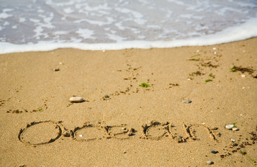 Word Ocean written on the sand