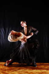 dancers in ballroom against black background