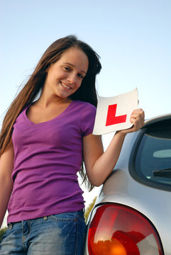 Young teenager holding learner plate