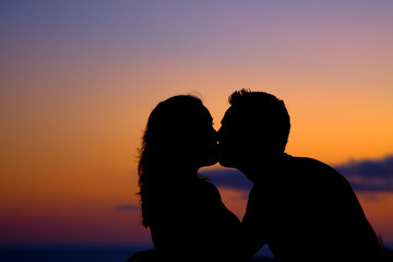 Silhouette of couple kissing at sunset