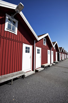 rote schwedische Bootshäuser an einem sonnigen Tag