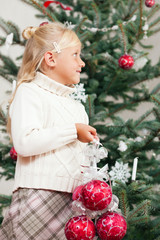 Kind schmückt den Weihnachtsbaum