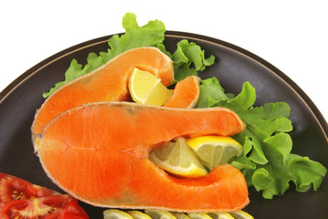 two salmon steak on dark dish