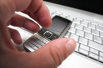 Hand takes mobile phone.