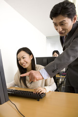 女性にパソコンを教えるスクール講師