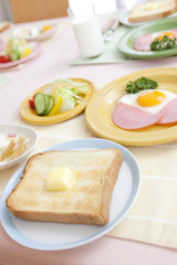 テーブルに置かれたトーストとハムエッグ
