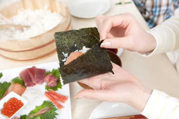 Obraz na płótnie Canvas 手巻き寿司を作る女性の手元