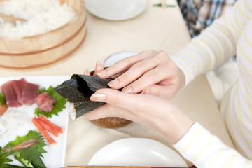 Obraz na płótnie Canvas 手巻き寿司を作る女性の手元
