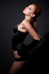 Attractive redhead model posing on dark background